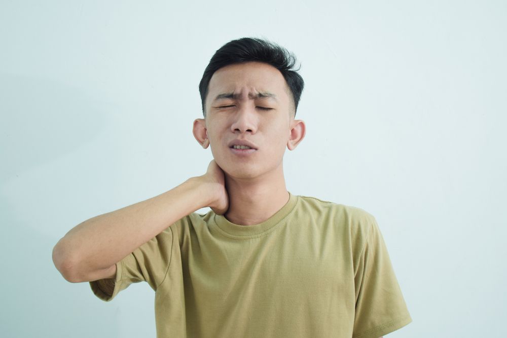Man touching neck with ache