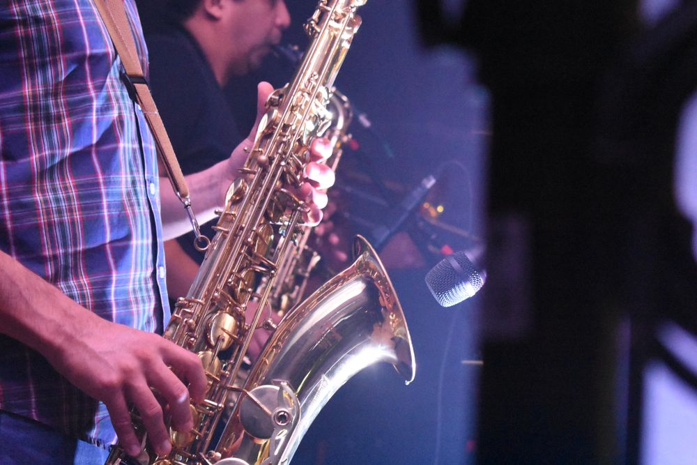 Two men playing saxophones on stage