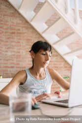 Woman working at laptop in bright loft 4MXaE5