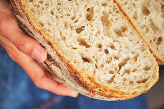 Hands holding bread broken in half