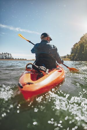Rear view image of a mature man canoeing in a lake