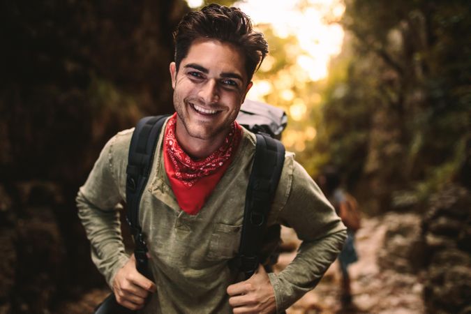 Man looking at camera and smiling while hiking in nature