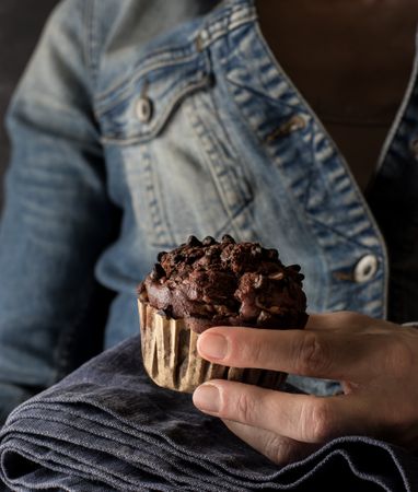 Crop woman with chocolate banana muffin