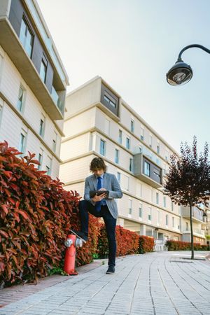 Businessman working with the tablet in the street