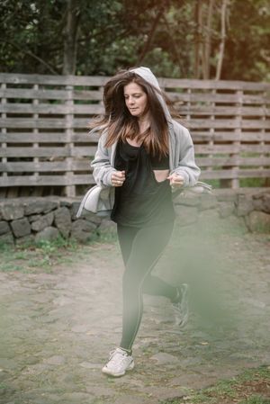 Positive woman running in park