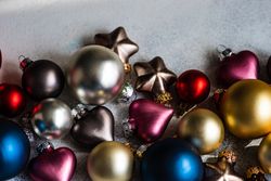 Christmas card concept of colorful baubles ornaments scattered on concrete counter