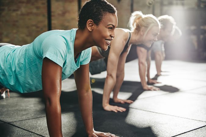 Woman planking in class with other people