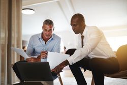 Two men working together focused in a laptop
