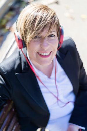 Portrait of businesswoman listening to music on red headphone