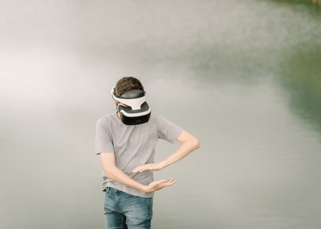 Young teenager with virtual reality glasses outdoors