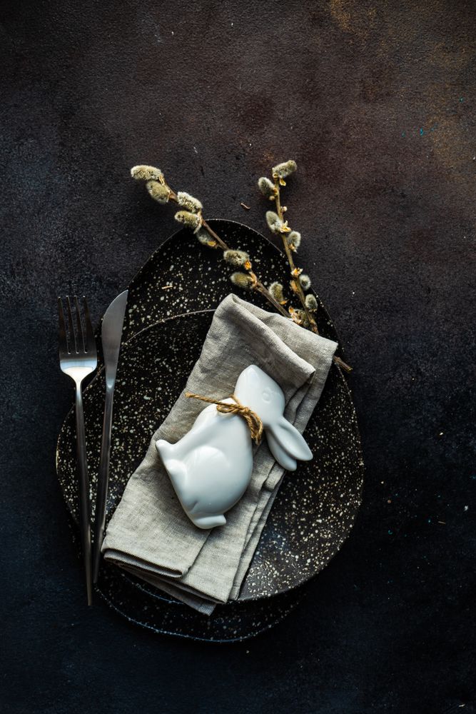 Easter table setting with ornamental rabbit and pussy willow branch on plate