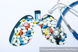 Close up of lung shape cut out of paper with pills underneath with doctor’s stethoscope 0yJ775