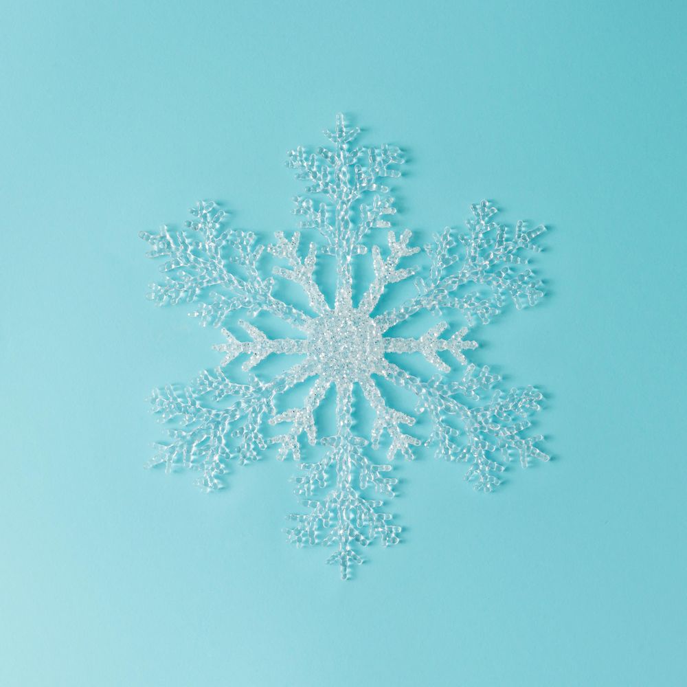 Single large snowflake on bright blue background