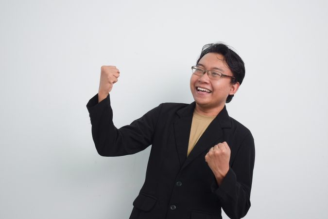 Happy businessman with hands up in glory