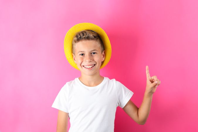 Boy with hat against color background, space for text