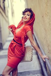 Elegant woman in dress leaning on rails of outdoor staircase