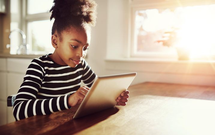 Shot of girl concentrating on laptop in sunny room