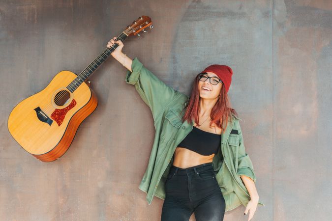 Woman in glasses leaning on wall