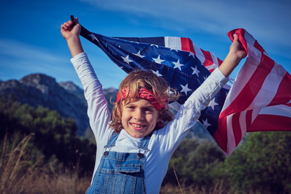 Happy preteen boy with waving American flag