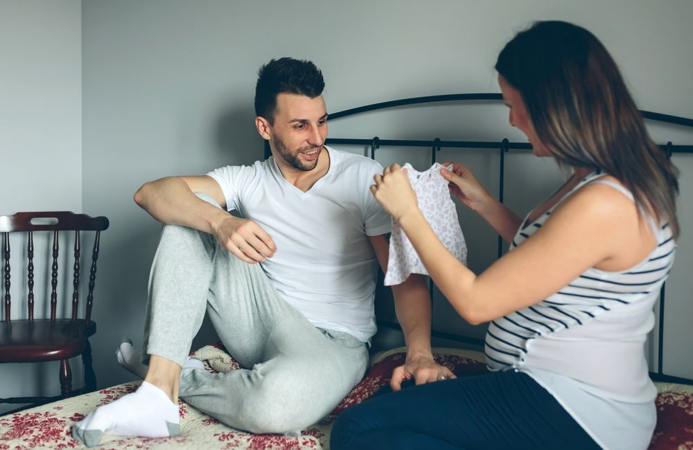 Pregnant showing dress to her husband