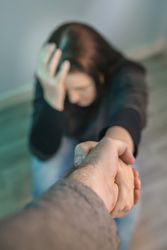 Unrecognizable woman receiving help from man holding her hand