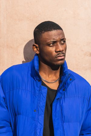 Black stylish man in warm jacket on street
