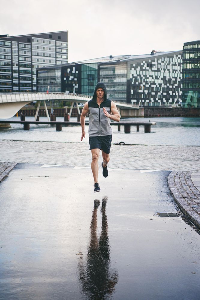 Muscular man in rain running in the rain