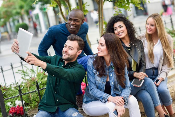 Women and men smiling taking a selfie wearing casual clothes
