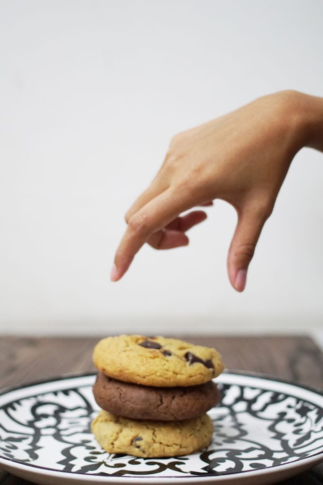 Hand reaching pile of cookies