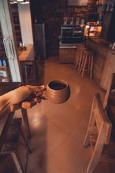 Crop person holding cup of coffee on table