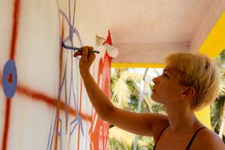 Woman painting on wall