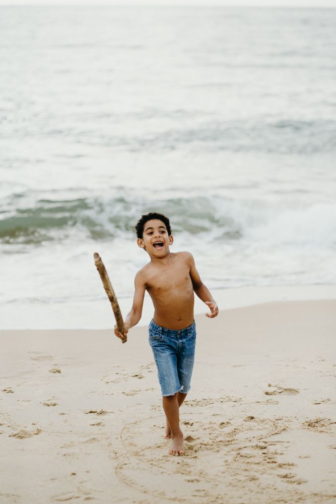 Black boy playing on beach