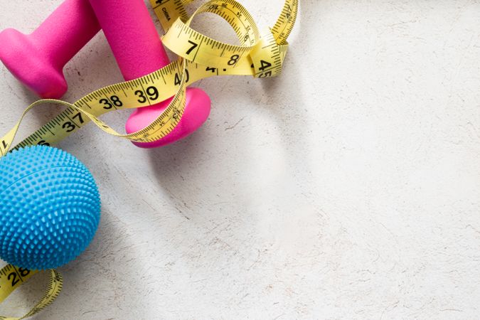 Dumbbells, Massage Ball And Measuring Tape on Fitness-Inspired Background