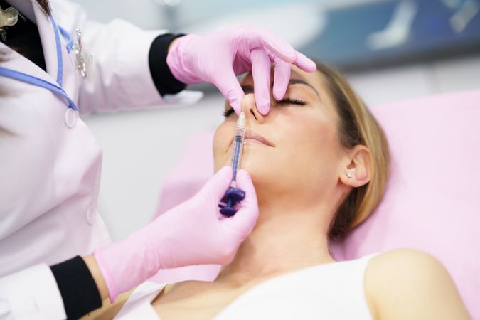 Woman having the base of her nose injected
