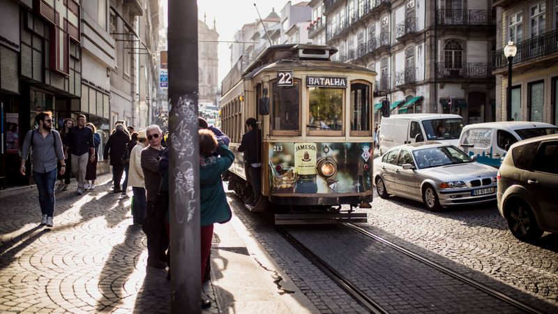 People walking on sidewalk near tram in Madeira, Portugal