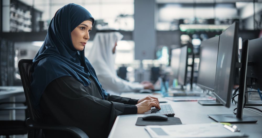 Middle Eastern Computer Scientist Wearing a Hijab, Working on PC in a Technological Corporate Office.