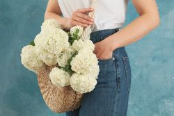 Beautiful fashionable woman with hydrangea flowers. Spring plant