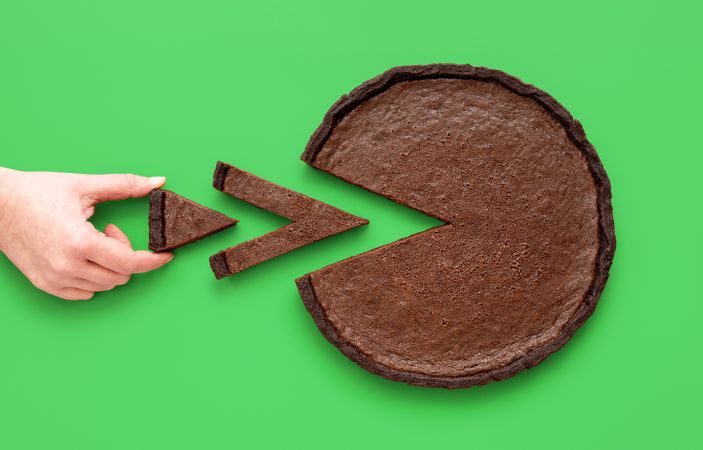 Pie chart concept, woman taking a small slice of chocolate tart