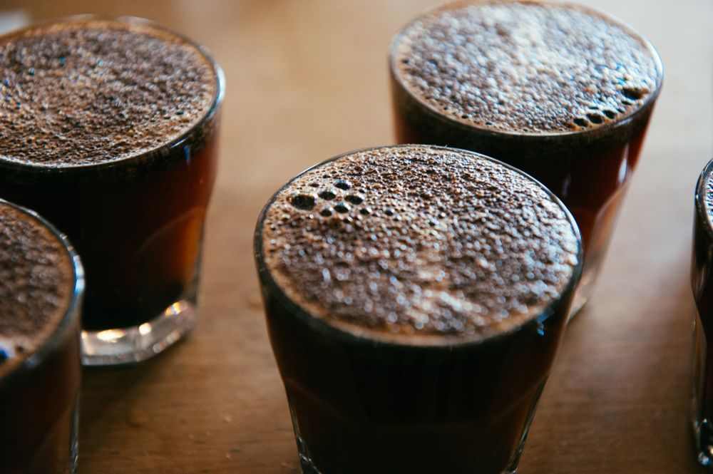 Close up shot of bubbles on top of hot coffee glasses