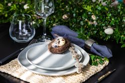 Easter table setting with eggs in nest on plate with natural light