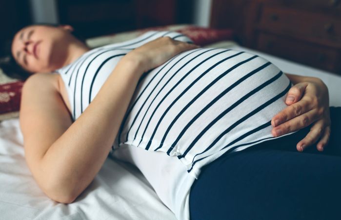 Pregnant woman sleeping in bed