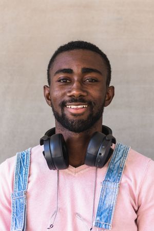 Smiling Black man with headphones on street