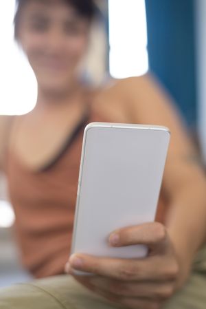 Happy woman blurred in background checking smartphone