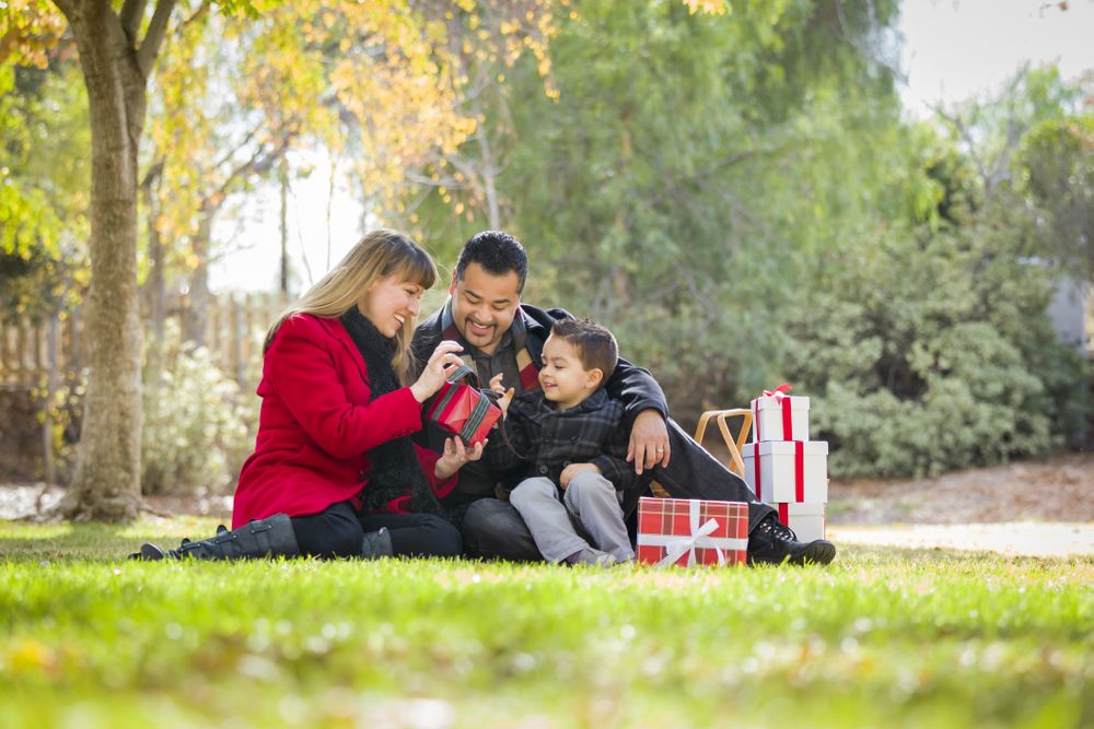 Family Enjoying Christmas Gifts in the Park Together