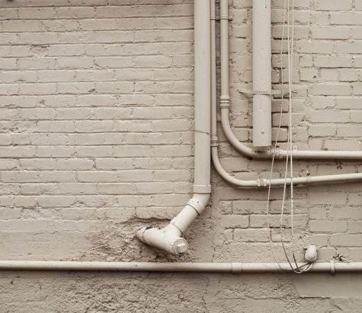 brick wall with white pipes
