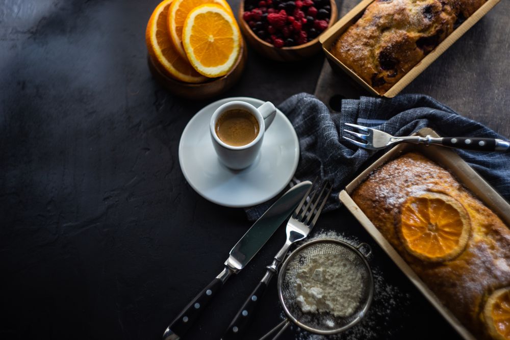 Espresso cup surrounded by freshly baked orange cake
