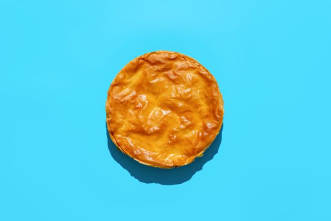 Phyllo dough cake with spinach and cheese, above view on a blue background