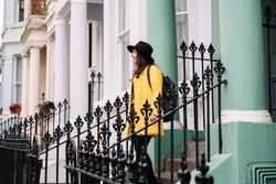 Cheerful woman standing in stairs in typical london buildings