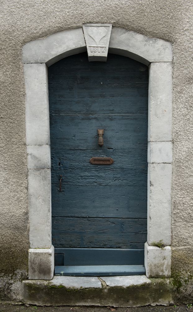 Building with blue door and flowers on steps