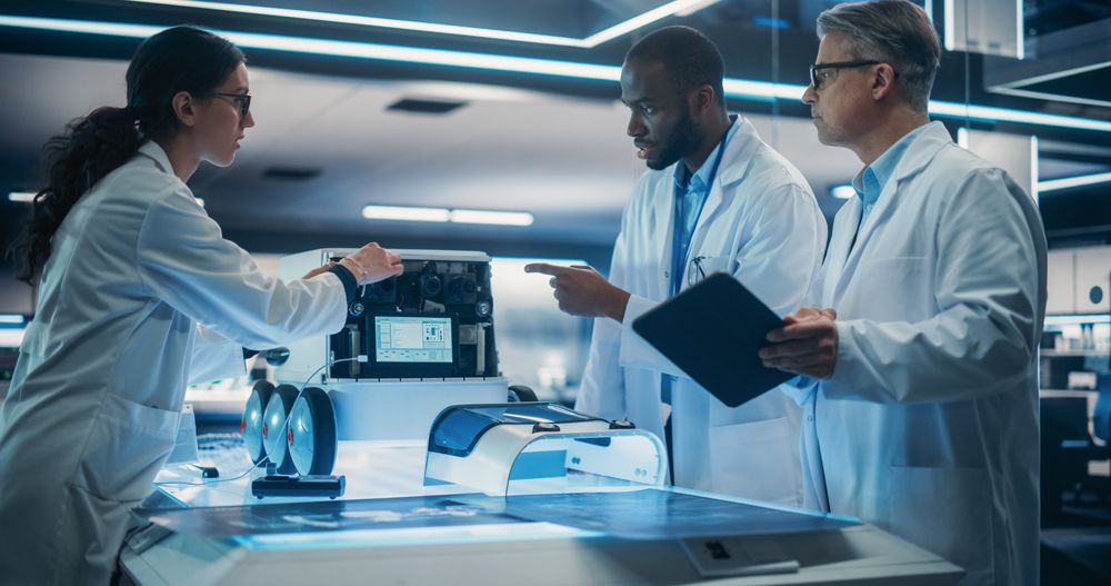 Black Engineer In Lab Coat Discussing an Automated AI Robotic Delivery Assistant with His Creative Team